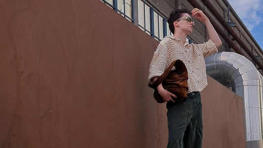 Man holding The Sail Bag, a brown leather suede totebag and wearing an bohemean style outfit.